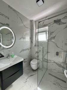 a bathroom with a toilet and a glass shower at Street Apartments in Ulcinj