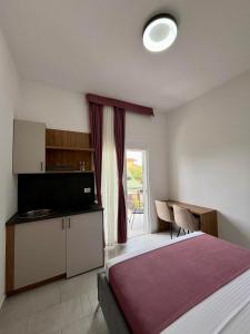 a bedroom with a bed and a table and a window at Street Apartments in Ulcinj