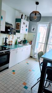 a kitchen with white cabinets and a table and a table and a table at Chambre dans appartement agréable et calme à 15 mn du Centre Ville in Annecy +13 photos