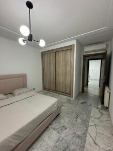 a bedroom with a bed and a ceiling fan at Glamorous Spacious 3BR at Jardin de Carthage Tunis in Sidi Daoud