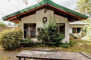 a small house with a table in front of it at Encantadora Casa con bosquecito in San Carlos de Bariloche
