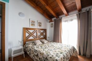 a bedroom with a bed and a large window at Casa Rural La Rosalia in Cogolludo +6 photos