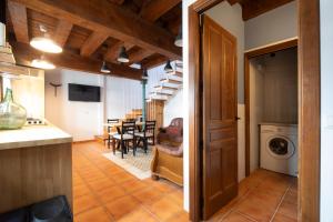 a kitchen and living room with a table and chairs at Casa Rural La Rosalia in Cogolludo