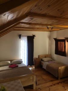2 letti in una camera con soffitti in legno di Private accommodation Kalezić a Mojkovac