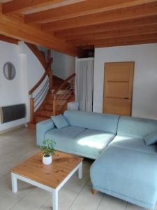 un soggiorno con un divano blu e un tavolo di Maison au coeur de Capbreton a Capbreton