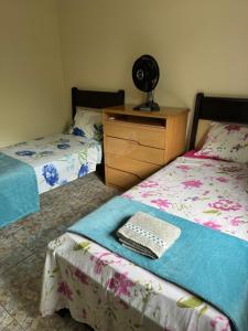a bedroom with two beds and a dresser with a keyboard at Casa Rodrigues in São Lourenço