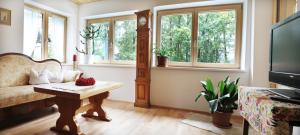 a living room with a couch and a table and windows at Haus König in Bezau