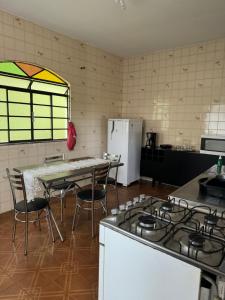 a kitchen with a stove and a table with chairs at Casa Rodrigues in São Lourenço