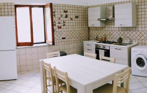 a kitchen with a white table and chairs at Villa Pina in Vico Equense +11 photos