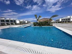 a large blue swimming pool with buildings in the background at Penthouse studio apartment in Kyrenia