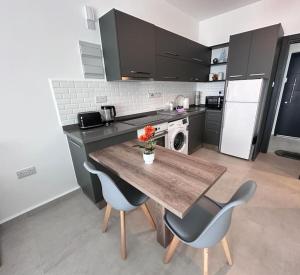 a kitchen with a wooden table and two chairs at Penthouse studio apartment in Kyrenia