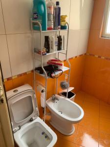 a small bathroom with a toilet and a sink at Apartment City Center Fier in Fier