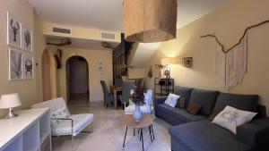 a living room with a blue couch and a table at Casa Pez in Ayamonte