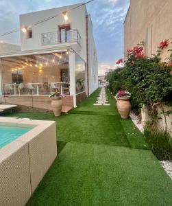 a house with a yard with green grass and a swimming pool at Ricordi Siciliani - Charme Rooms in San Vito lo Capo