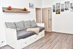une chambre avec un lit blanc dans une pièce dans l'établissement Karlsbad City Apartment, à Karlovy Vary
