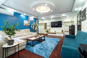 uma sala de estar com um sofá e uma parede azul em Universo Romantico em Lisboa