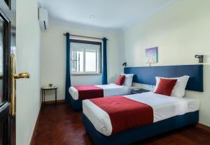 - deux lits dans une chambre bleue et rouge dans l'établissement Universo Romantico, à Lisbonne