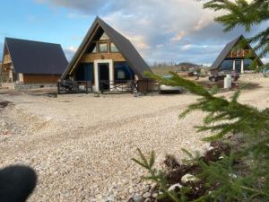 a home with a gambrel roof and a gravel yard at Runolist Chalet in Žabljak