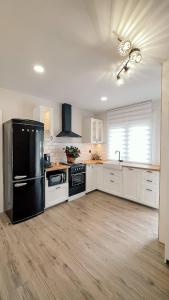a kitchen with a black refrigerator and white cabinets at O Lar de Laura in Vigo