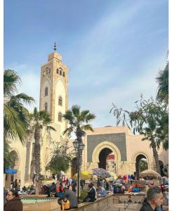 a building with a clock tower with a crowd of people at Élégant Appartement près grand bazar "Souk elhad" in Agadir