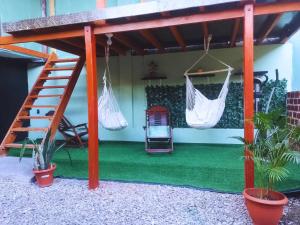 hotel Suyay Lodge Tarapoto في تارابوتو: فناء مع أرجوحة و منزل