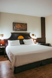 a bedroom with a large bed with a wooden headboard at Batel Luxury - Próx Pátio Batel in Curitiba