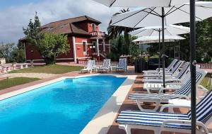 a group of chairs and umbrellas next to a pool at Villa Burión in Llanera