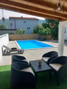 莫斯塔尔Portofino Guest House Blagaj的后院设有带椅子和桌子的游泳池
