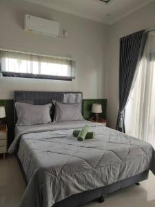 CireungitVilla galunggung rooftop Tasikmalaya的卧室里有一张床，床上有一只泰迪熊
