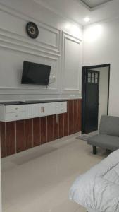 CireungitVilla galunggung rooftop Tasikmalaya的一间房间,配有一张床和墙上的电视