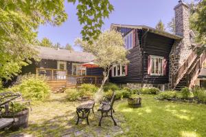 a yard with a bench in front of a house at Auberge Le Lupin-Self Check-in in Mont-Tremblant