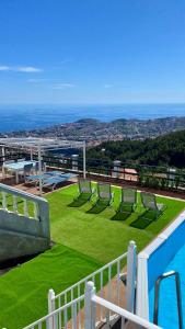 a balcony with lawn chairs and a swimming pool at Studio Geek Villa - Open Space - 5m from 5 top attractions - Pool all year round, Dining Pergola, Barbecue - Funchal Matrix Holiday Home in Funchal