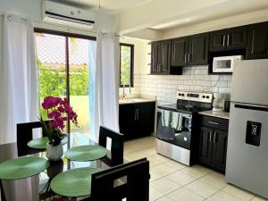 a kitchen with a table and chairs and a refrigerator at Charming Condo Orchidea in Coco