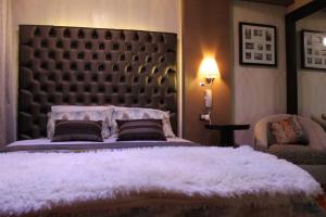 sypialnia z dużym łóżkiem z dużym zagłówkiem w obiekcie Hotel Venecia w mieście Huánuco