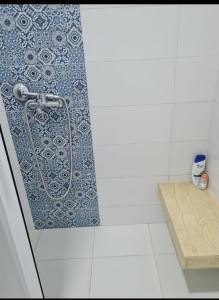 een douche in een badkamer met een blauwe en witte muur bij Mestura Marina Tanger in Tanger
