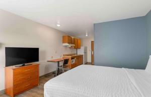 デイトンにあるExtended Stay America Select Suites - Dayton - Miamisburgのベッドとテレビ付きの机のある寝室