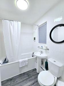 Un baño blanco con inodoro y lavabo. en LushStay Telford - Families, Contractors & Group of Friends, long term stay, en Telford