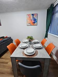 una mesa de comedor con sillas y platos. en LushStay Telford - Families, Contractors & Group of Friends, long term stay, en Telford