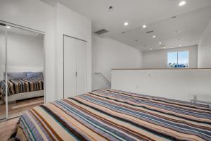 ein weißes Schlafzimmer mit einem Bett und einem Fenster in der Unterkunft Stylish Modern one Bedroom Hollywood Loft With in unite washer dryer & Balcony in Los Angeles