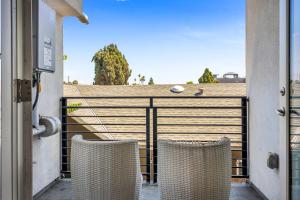 2 Stühle auf einem Balkon mit einem Zaun in der Unterkunft Stylish Modern one Bedroom Hollywood Loft With in unite washer dryer & Balcony in Los Angeles