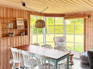 une salle à manger avec une table et des chaises en bois dans l'établissement 6 person holiday home in Hadsund, à Hadsund
