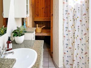une salle de bain avec un lavabo et un rideau de douche dans l'établissement 6 person holiday home in Hadsund, à Hadsund 40 autres photos