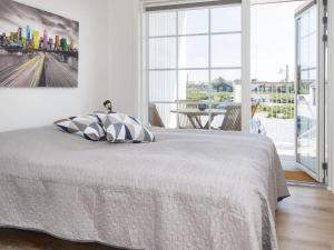 a white bedroom with a bed and a large window at 4 person holiday home in Ringkøbing-By Traum in Ringkøbing