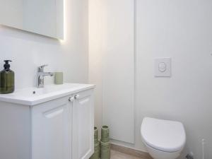 a white bathroom with a toilet and a sink at 4 person holiday home in Ringkøbing-By Traum in Ringkøbing +46 photos