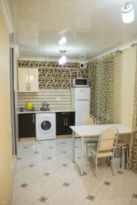 a kitchen with a table and a table and chairs at Apartment Decebal in Chişinău