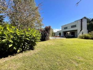 a building with a grassy yard in front of it at Mediterranean Country House - La Plata in City Bell +32 photos
