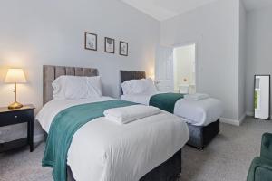 een slaapkamer met twee bedden met witte lakens bij Modern Apartment King with Free Parking Suite 6 in Nottingham