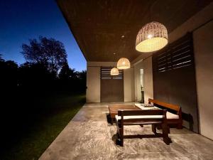 a patio with a table and a bench and lights at Mediterranean Country House - La Plata in City Bell