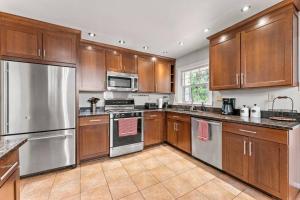 a kitchen with wooden cabinets and stainless steel appliances at Picture-Perfect Charmer in North Decatur in Decatur +10 photos