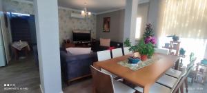a dining room and living room with a table and chairs at Villamuz in Yalıkavak